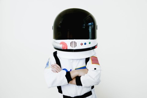 Mixed race boy in astronaut costume