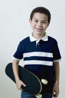 Mixed race boy holding skateboard