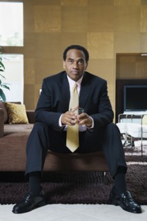 Confident African businessman sitting in modern living room
