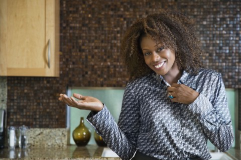 Proud African woman showing off modern kitchen