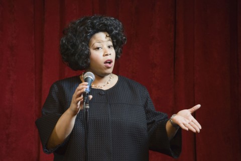 African woman singing on stage