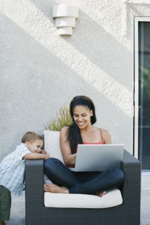 Mother and son looking at laptop on patio