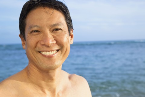 Japanese man smiling on beach
