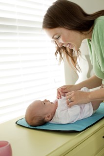 Caucasian mother changing baby daughter