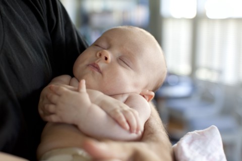 Caucasian father holding baby daughter