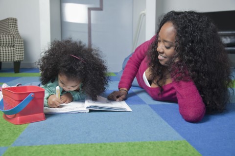 Mixed race mother watching daughter color
