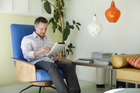 Man using digital tablet in living room