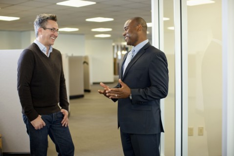 Smiling businessmen talking together in office