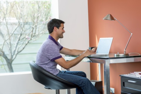 Mixed race man using laptop