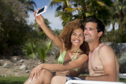 Mixed race couple taking self-portrait with cell phone