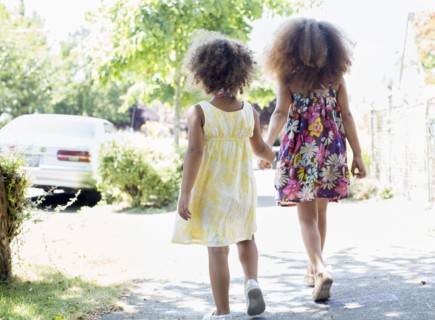 Mixed race sisters holding hands