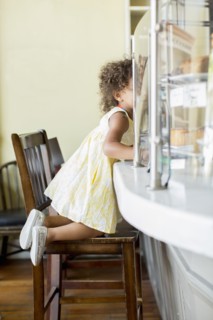 Mixed race girl kneeling at counter