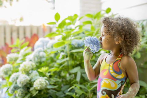 Mixed race girl smelling flower