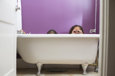 Mixed race girls playing in bathtub