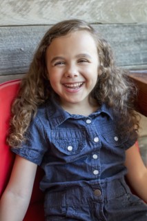 Smiling mixed race girl sitting in chair