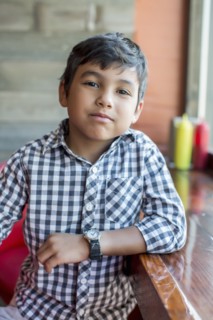 Mixed race boy sitting in restaurant