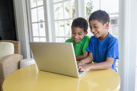 Hispanic boys using laptop