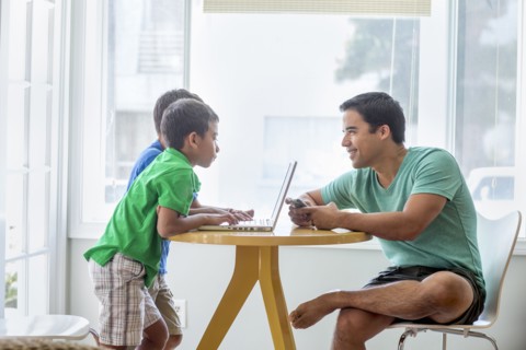 Father and sons talking at table