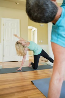 Caucasian people practicing yoga in home