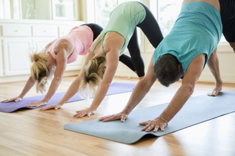 Caucasian people practicing yoga in class