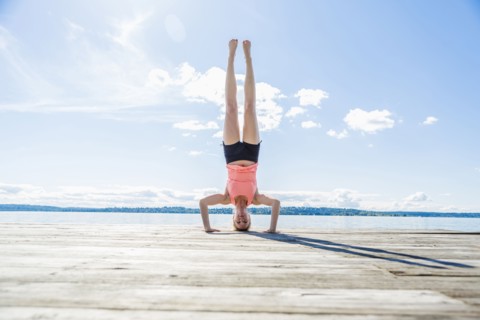 Caucasian woman practicing yoga on wooden dock