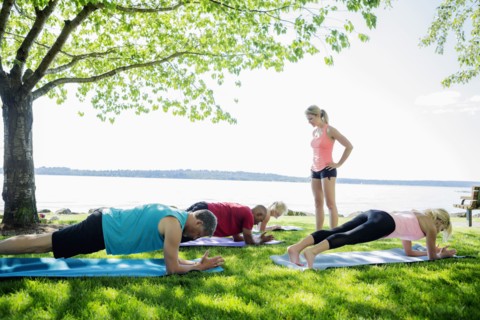 Caucasian people practicing yoga outdoors