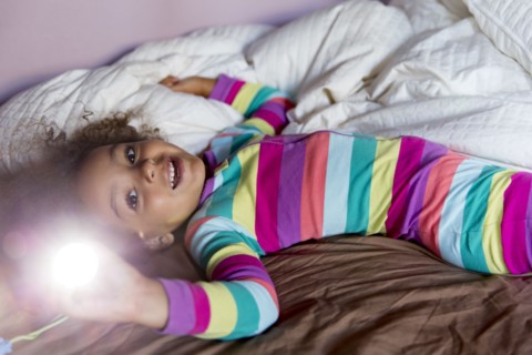 Mixed race girl smiling on bed