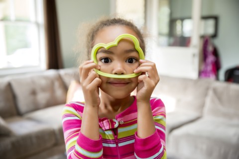 Mixed race girl playing with cookie cutter