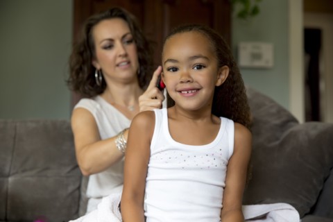 Mother fixing daughter's hair