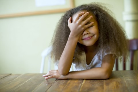 Mixed race girl laughing at table