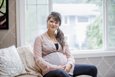 Pregnant Caucasian woman sitting on sofa