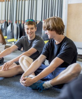 Caucasian boys stretching in boathouse