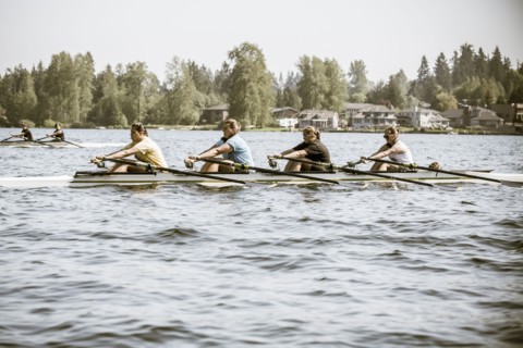 Teenagers rowing scull on lake