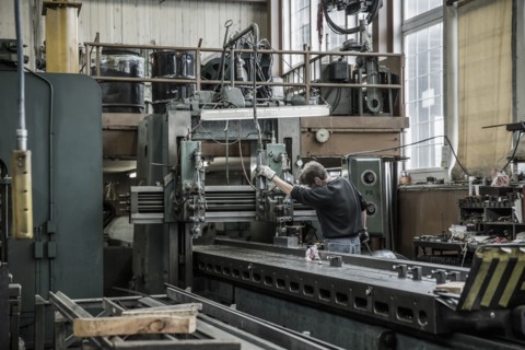 Caucasian man using machinery in metal shop