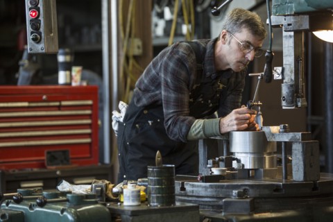 Caucasian man using machinery in workshop