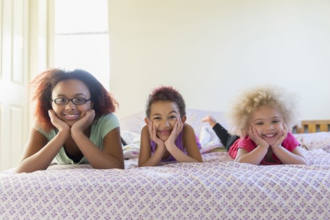 Mixed race sisters laying in bed