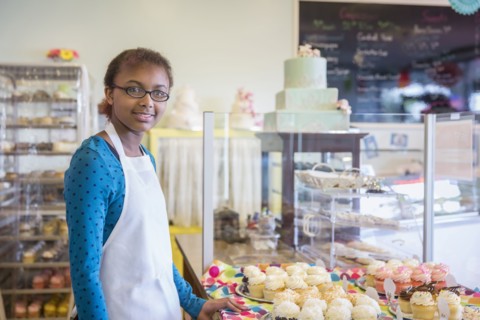 Mixed race girl baking in commercial kitchen