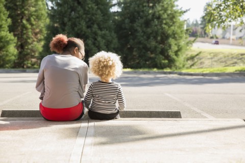 Mixed race sisters sitting outdoors