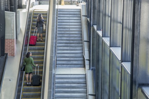 Businesswomen riding escalator
