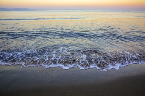 Waves washing up on sandy beach