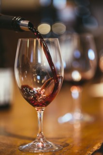 Close up of wine pouring into glass on table