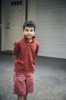 Mixed race boy standing on driveway