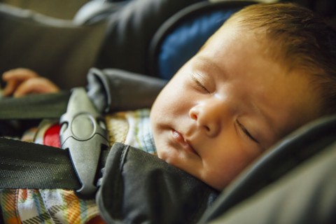 Caucasian baby boy sleeping in car seat