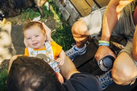 Caucasian gay couple relaxing with baby boy outdoors