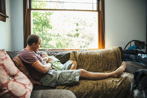 Caucasian father sitting with baby boy on sofa