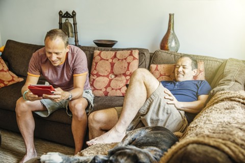 Caucasian gay couple relaxing in living room