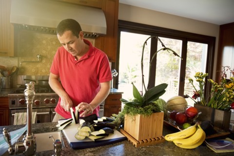 Caucasian man chopping vegetables in kitchen