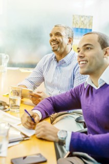 Businessmen laughing in office meeting
