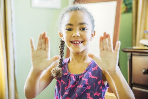 Mixed race girl showing chalky hands