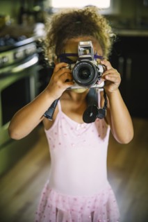 Mixed race girl photographing with camera